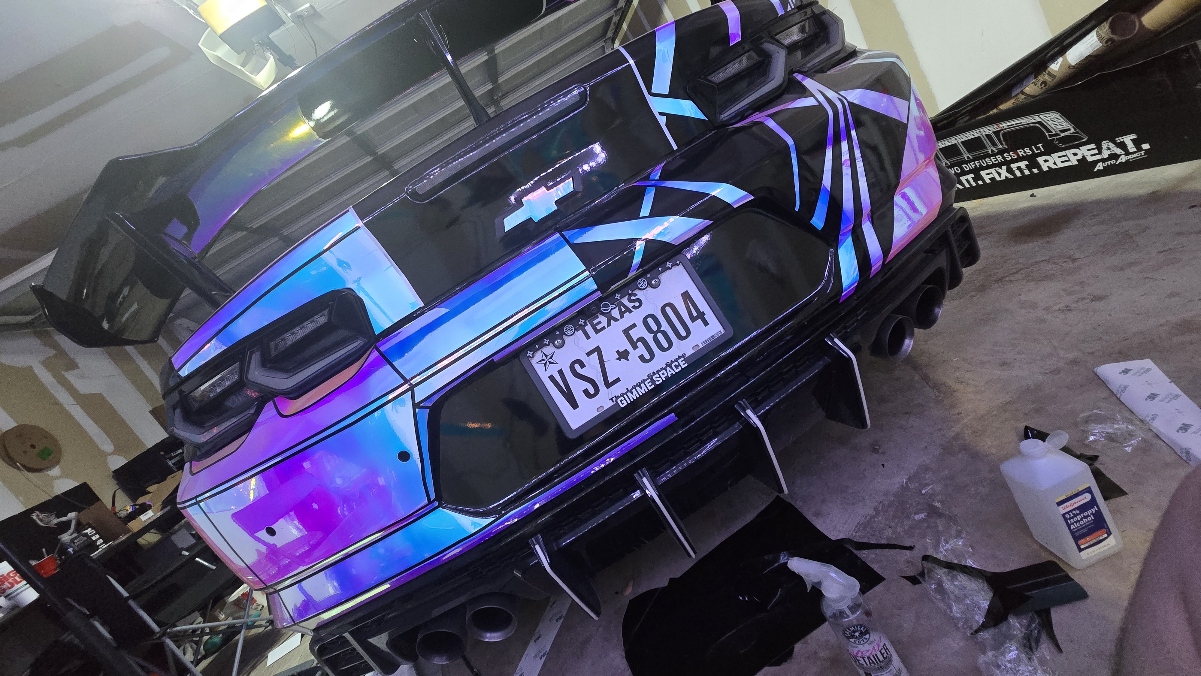 Custom black Chevrolet bowtie graphics installed across the quarter panel of a red 6th Gen Chevrolet Camaro.