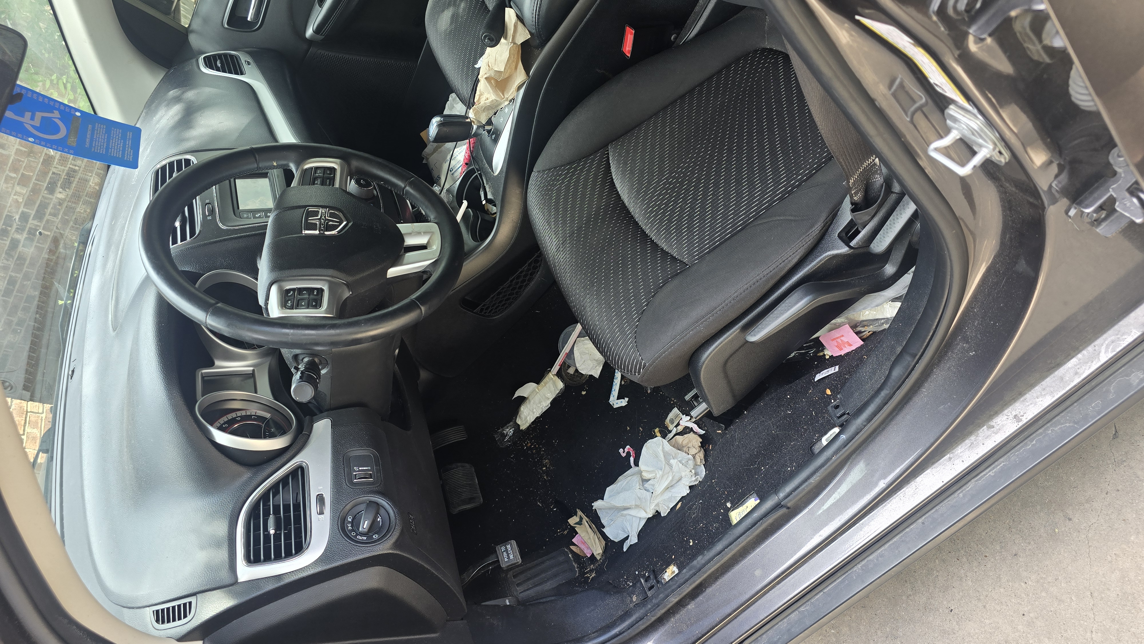 Driver's side interior of a Dodge Journey before a full interior detailing service.